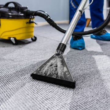 Photo Of Janitor Cleaning Carpet With Vacuum Cleaner